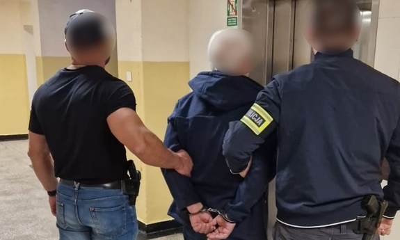 zatrzymany zakuty w kajdanki prowadzony przez dwóch policjantów
