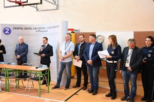 Na obrazku widać zaproszonych gości na Turniej Motoryzacyjny, który odbywał się w Zespole Szkół Usługowo- Gospodarczych w Pleszewie w dniu 25 kwietnia 2019 roku, a także organizatorów konkursu, m.in. Wicestarosta Pleszewski, dyrektor ZSUG w Pleszewie i policjanci.