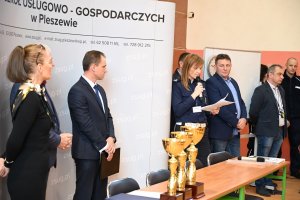 Na obrazku widać zaproszonych gości na Turniej Motoryzacyjny, który odbywał się w Zespole Szkół Usługowo- Gospodarczych w Pleszewie w dniu 25 kwietnia 2019 roku, a także organizatorów konkursu, m.in. Wicestarosta Pleszewski, dyrektor ZSUG w Pleszewie i policjanci.

Główny sędzia zawodów podinsp. Anita Piechocka odczytuje zasady, które obowiązują podczas tego konkursu.
