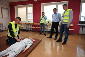 Uczestnicy Turnieju zmagają się ze sprawdzianem z Pierwszej Pomocy. Na obrazie widać uczniów, z których jeden prowadzi masaż serca na specjalnie przygotowanym do tego fantomie.