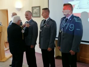 Na zdjęciu widać policjantów odznaczonych: Medalem Pamiątkowym 75-lecia za zasługi dla Ligi Obrony Kraju odznaczeni zostali:
 
insp. Roman Pisarski - Komendant Powiatowy Policji w Pleszewie
nadkom. Tomasz Mimier - Zastępca Komendanta Powiatowego Policji w Pleszewie
asp. szt. Łukasz Ptak