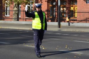 światło zielone dla jadących z lewej strony policjanta; policjant dodatkowo wstrzymuje ruch z jego prawej strony