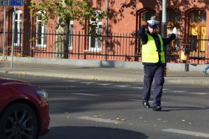 światło zielone dla jadących z prawej strony policjanta (prosto i w lewo), policjant dodatkowo wstrzymuje ruch z jego lewej strony (2)