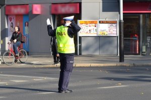 światło zielone dla jadących z prawej strony policjanta (prosto i w lewo), policjant dodatkowo wstrzymuje ruch z jego lewej strony (2)