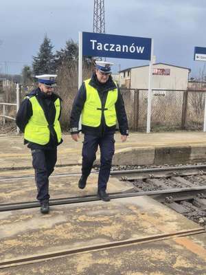 Policjanci idą przodem do zdjęcia, zdjęcie wykonane na torowisku w Taczanowie