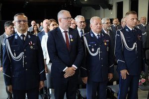 Na obrazie widać policjantów, którzy stoją obok siebie. Zdjęcie wykonane podczas obchodów Święta Policji.