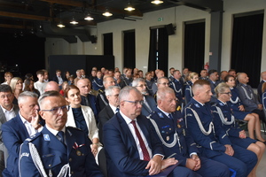 Na obrazie widać policjantów siedzących na krzesłach. Zdjęcie wykonane podczas obchodów Święta Policji