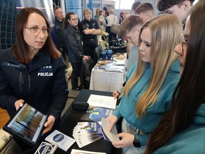 Na obrazie widać policjantki, które rozmawiają z kandydatami do służby w policji. Spotkanie - targi pracy odbyły się w OHP w Pleszewie. Podczas tegorocznych targów pracy, pleszewscy policjanci promowali zawód policjanta. Zainteresowane osoby dowiedziały się, jakie dokumenty należy złożyć i jak wyglądają poszczególne etapy postępowania kwalifikacyjnego.