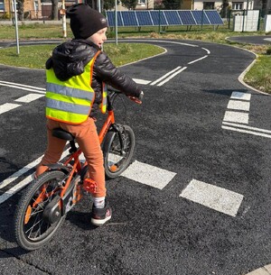 Przedszkolak jedzie na rowerze na miasteczku ruchu drogowego