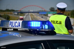 Na obrazie widać policjanta na drodze, który pilnuje porządku na drodze