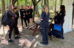 Na zdjęciu widać policjantki, które prezentują stoisko policyjne studentom podczas zajęć w GOTiS